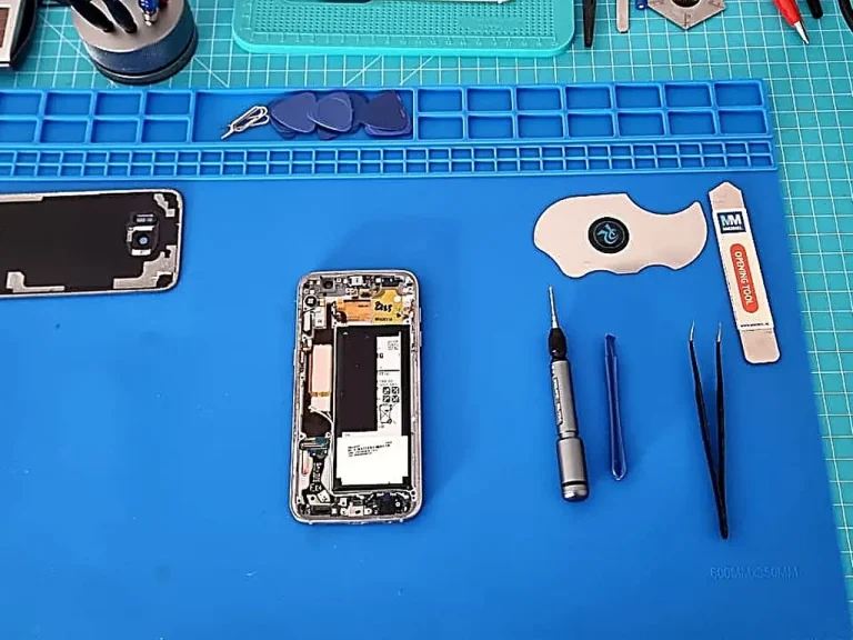 Schnelle Elektronik-Reparatur für Smartphones mit Original-Ersatzteilen Aufgeklapptes iPhone auf blauer Reparaturmatte mit professionellen Werkzeugen und Komponenten